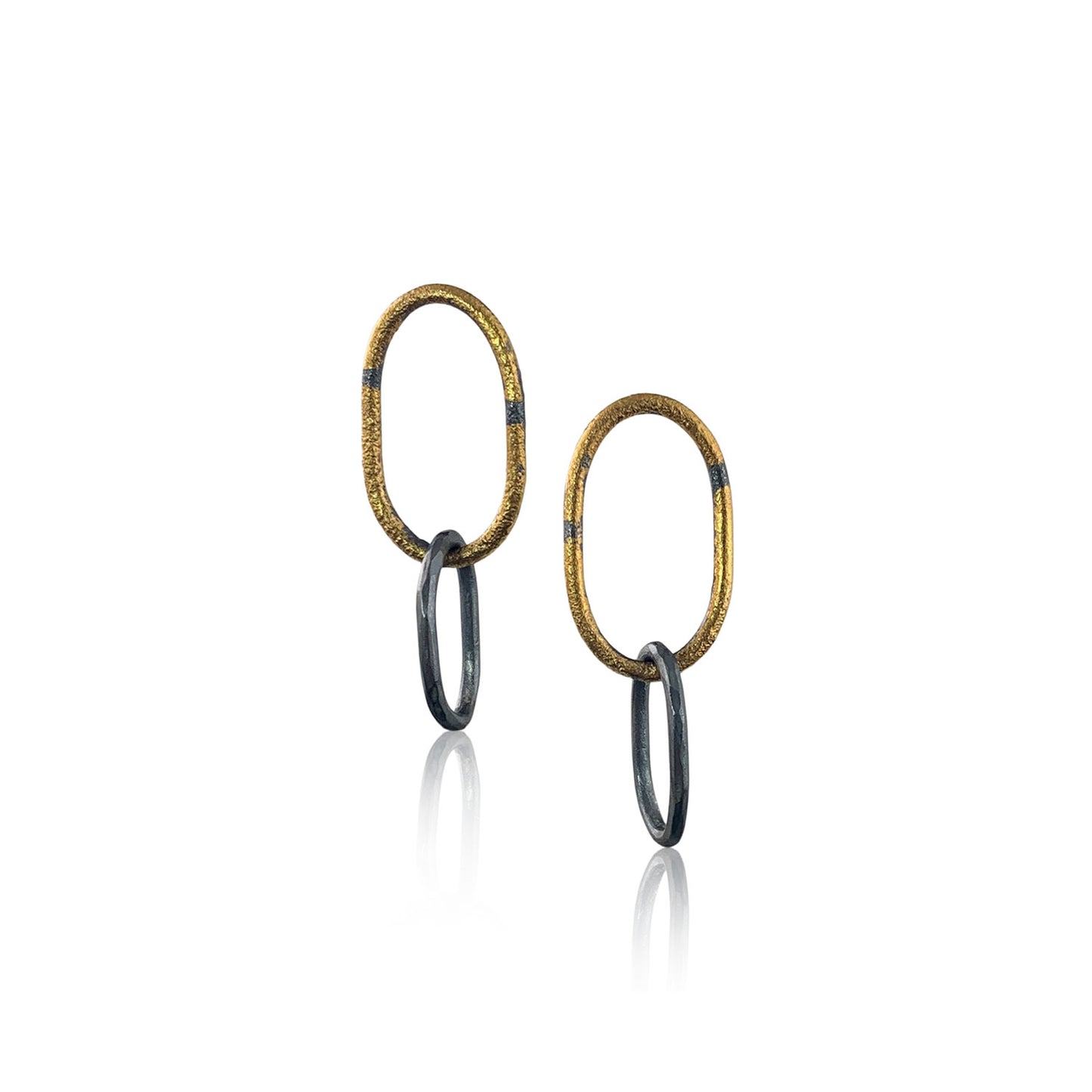 Front view of two earrings. Each has one large textured gold oval loop at the top, with a smaller textured oxidized silver loop through the bottom.