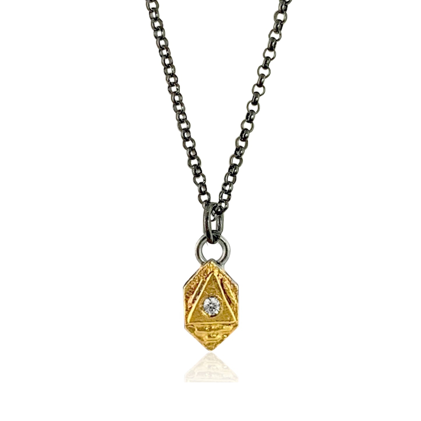 A long gold hexagon with a gold triangle on top holds a small white diamond. The pendant hangs from two silver rings, which hang from a sturdy oxidized sterling silver chain.