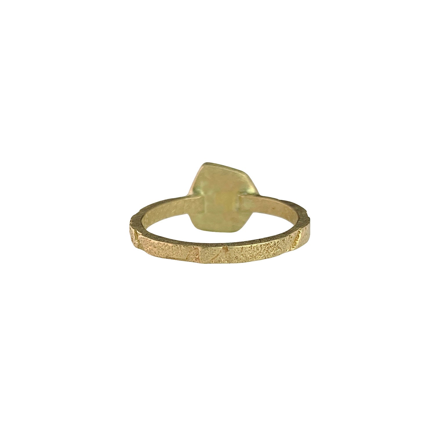 Back view of a ring with a narrow, textured gold band. On the far side of the band, there's a round gold disc that houses the diamond on the other side.
