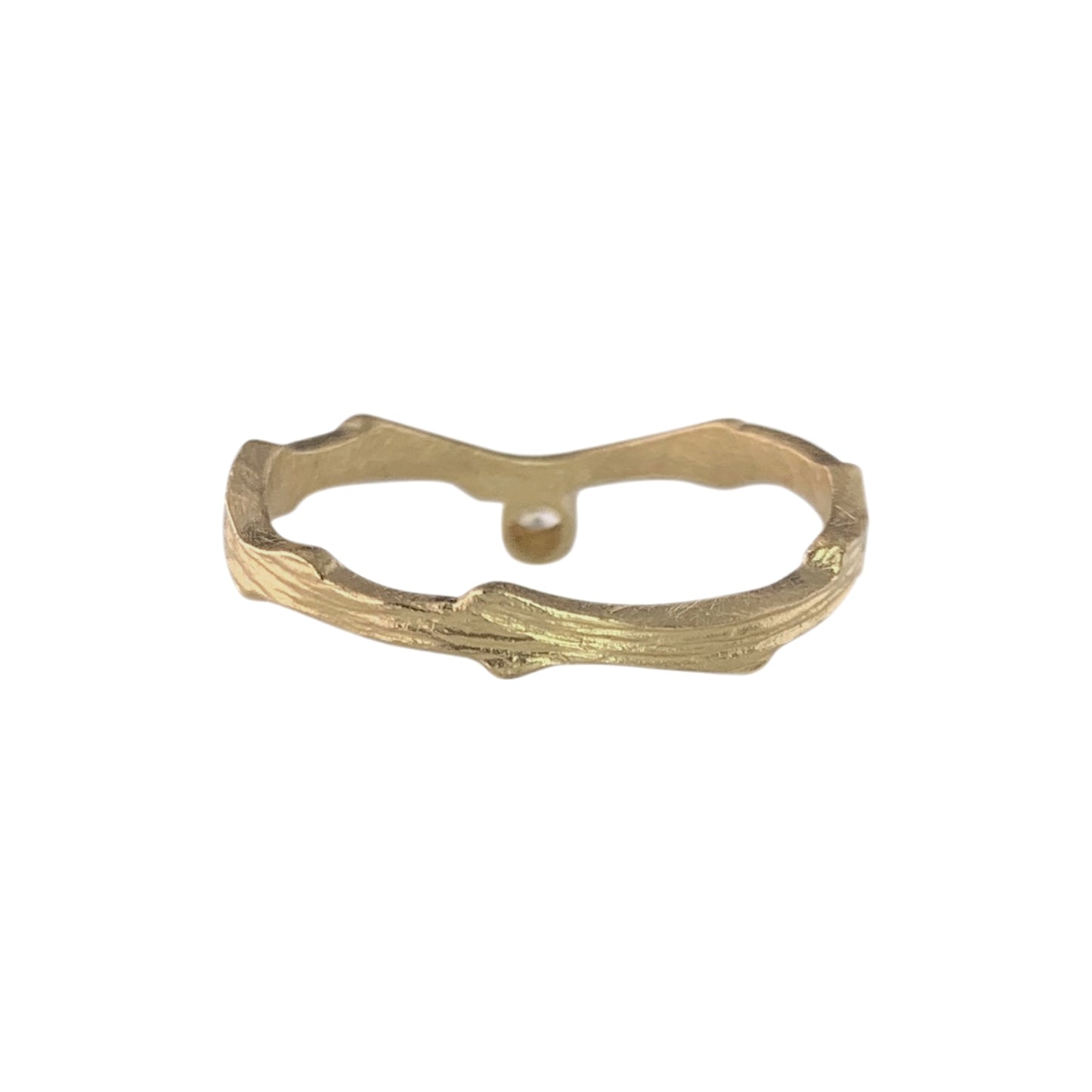 Back view of a gold ring with a wavy, textured band. On the far side of the band is a gold disc that holds an almost flush diamond on the other side.