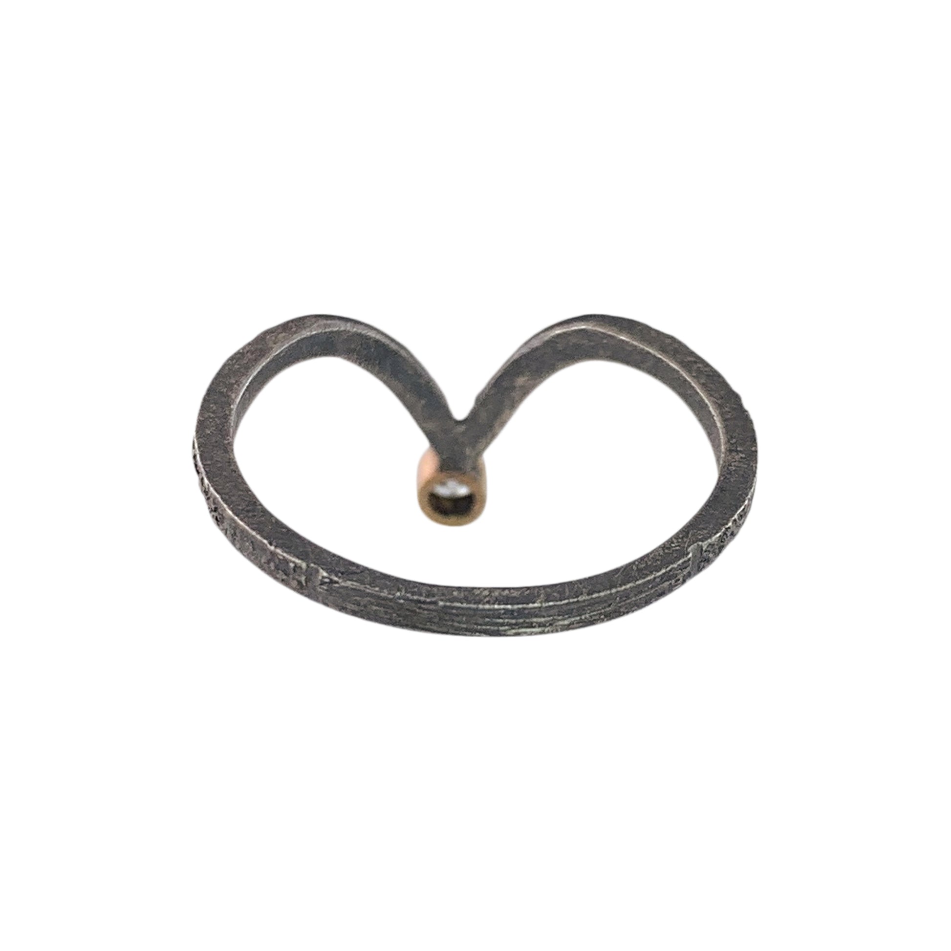 Back view of a textured dark gray band with a V shape on the far end. At the bottom of the V is smooth yellow gold, which holds a diamond (not visible).